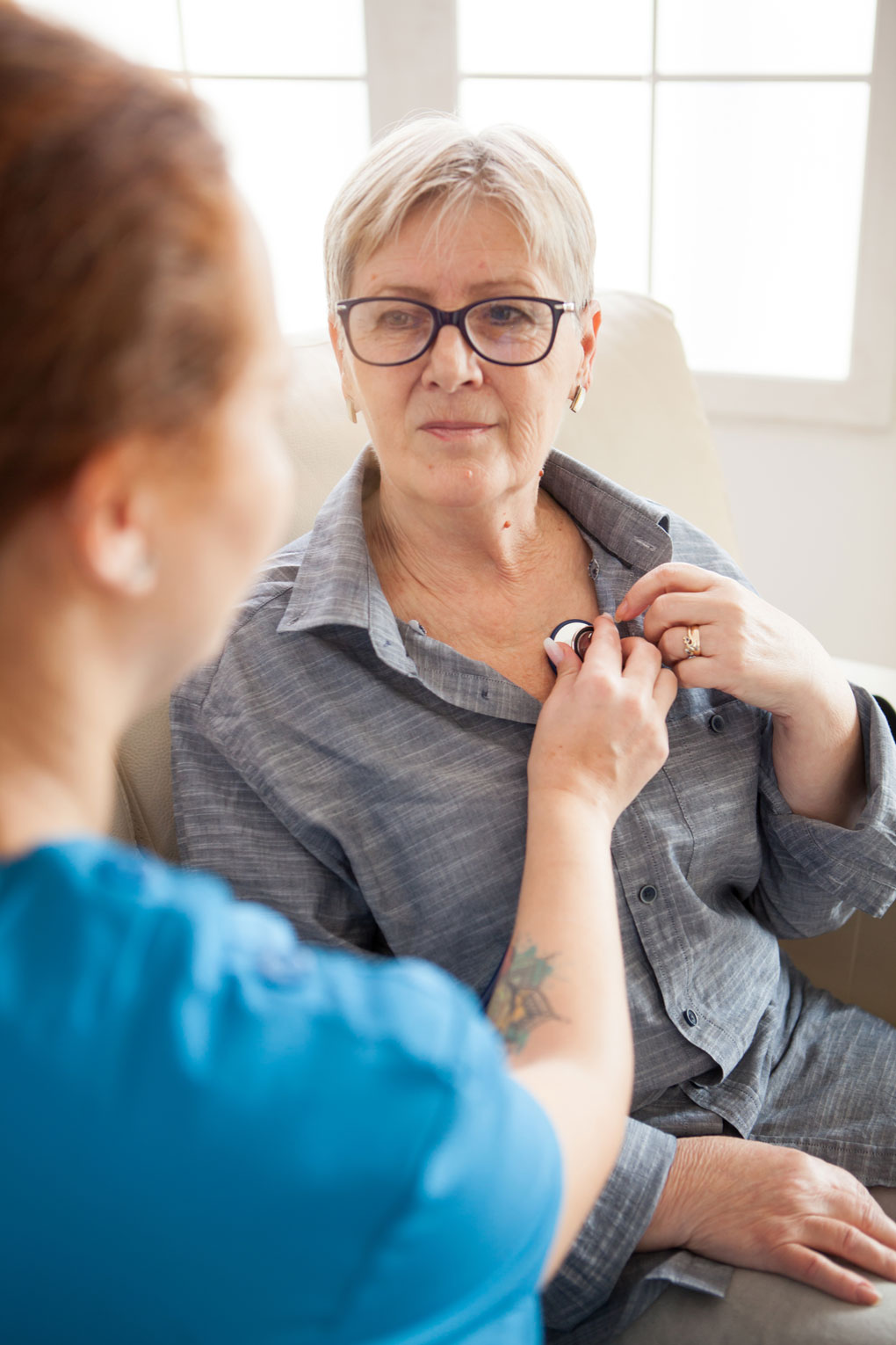 back-view-female-nurse-using-stethoscope-nursing-home-listen-old-woman-heart-beat.